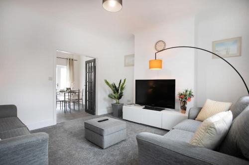 a living room with a couch and a flat screen tv at Cudworth House, Barnsley for contractors & Families, off-road parking, speedy WIFI,etc in Barnsley