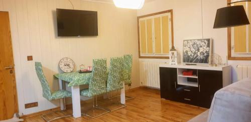 een woonkamer met een tafel en stoelen en een televisie bij The Family 1 in Canfranc-Estación