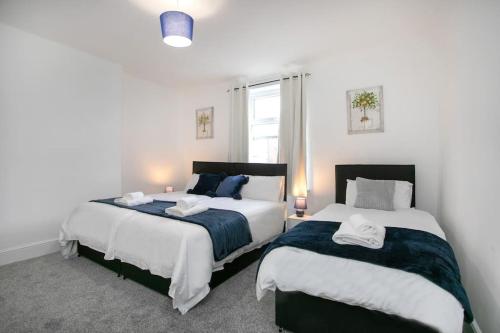 1 dormitorio con 2 camas y ventana en Cudworth House, Barnsley for contractors, families & Biz en Barnsley