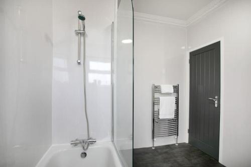 a white bathroom with a shower and a tub at Cudworth House, Barnsley for contractors & Families, off-road parking, speedy WIFI,etc in Barnsley