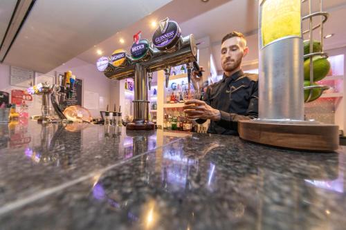 a man sitting at a bar in a barber shop at Lyndene Hotel in Blackpool