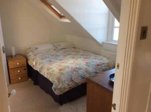 ein Schlafzimmer mit einem Bett, einer Kommode und einem Fenster in der Unterkunft Cosy Loft Apartment in Georgian Home in Plymouth