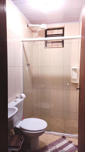 a bathroom with a toilet and a sink at Hospedaria Recanto dos Pássaros in Morretes