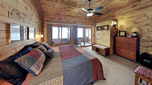 um quarto com uma cama num chalé de madeira em Tranquility On Teal Lake em Hayward