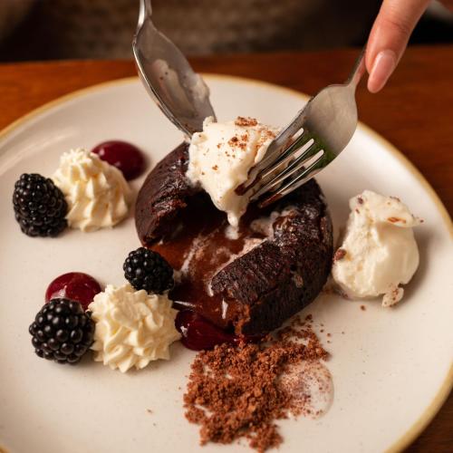 a person eating a chocolate dessert with a fork at Fairfield House Hotel in Ayr