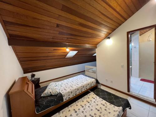 um pequeno quarto com uma cama e um tecto em madeira em Casa com vista deslumbrante próximo a feirinha em Teresópolis