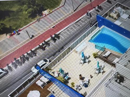 uma vista superior de uma piscina com mesas e cadeiras em Beira Mar Premium Apart - Solar do Atlântico Tambaú em João Pessoa