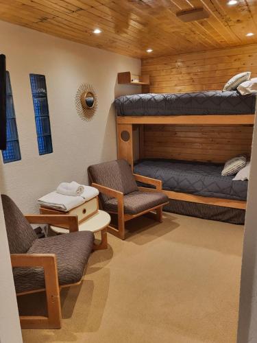 a room with two bunk beds and two chairs at Departamento en Edificio Atenas con excelentes Vistas in Las Lenas