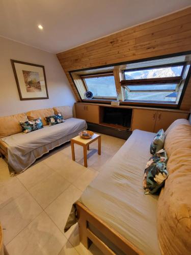 a living room with two beds and a window at Departamento en Edificio Atenas con excelentes Vistas in Las Lenas