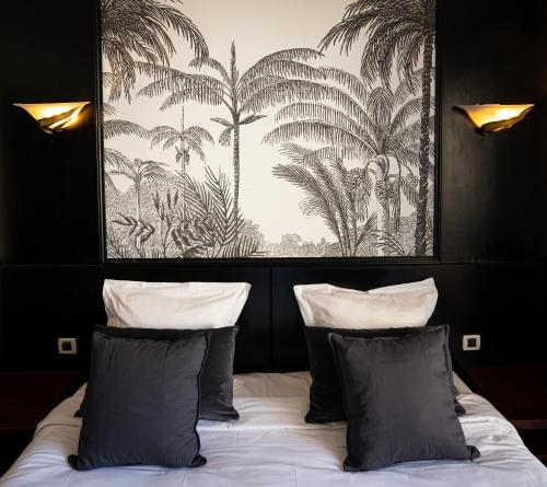 a bedroom with a bed with two pillows and a painting at Hôtel Gallia Cannes in Cannes