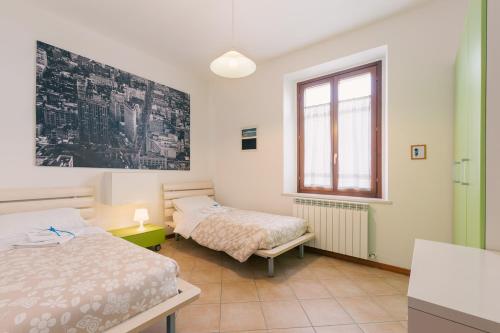 a bedroom with two beds and a window at Appartamento Prima Fila Mare , La Vecchia Chiesa in Marotta