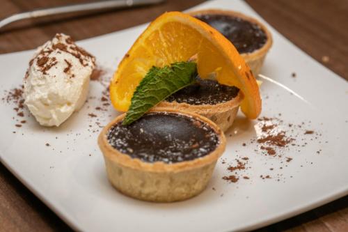 a white plate with three desserts on a table at Lyndene Hotel in Blackpool