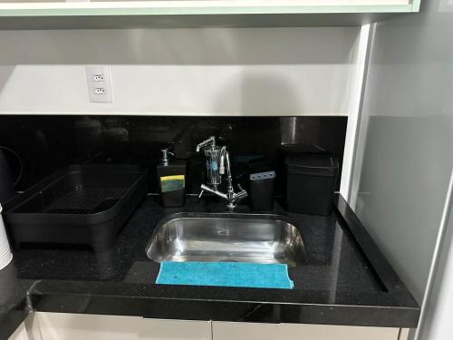 a kitchen sink with a blue towel next to it at Studios Astral central piscina coz completa in Juiz de Fora