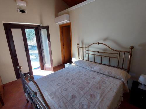 a bedroom with a bed in a room with a window at Casal Finocchito in Ogliastro Cilento