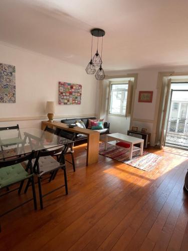 uma sala de estar com uma mesa e um sofá em Apartamento central para grupo ou familias em Lisboa
