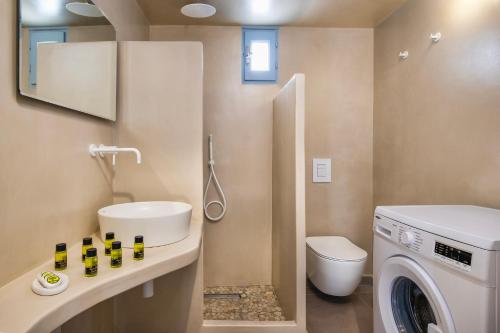 a bathroom with a washing machine and a washer at Ann-Margo House in Fira
