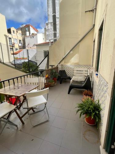 uma varanda com uma mesa e cadeiras num edifício em Apartamento central para grupo ou familias em Lisboa