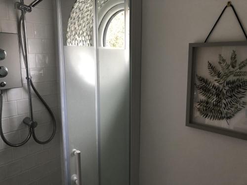 a shower with a glass door in a bathroom at Woodland House B & B in Wimborne Minster