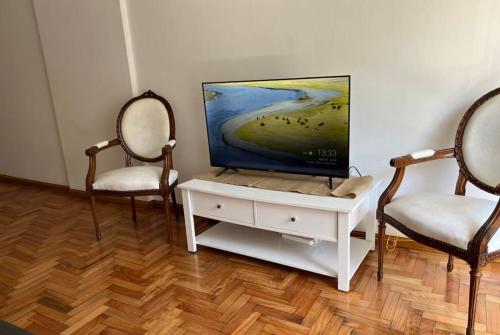 sala de estar con 2 sillas y TV de pantalla plana en Amigable departamento en palermo en Buenos Aires