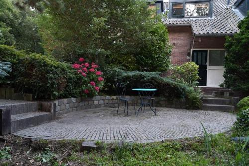 two chairs and a table in front of a house at Villa in the forest of Amsterdam with Pool in Velsen-Zuid