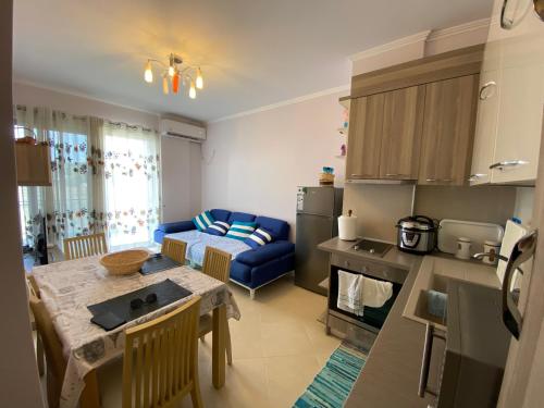 Una cocina y una sala de estar con una mesa y un sofá. en Dana’s home&sea, en Vlorë