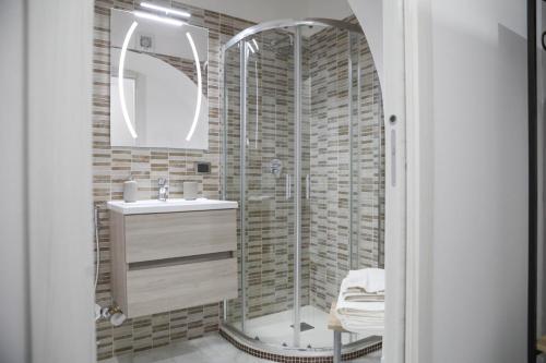 a bathroom with a glass shower and a sink at Kellas home in Bari