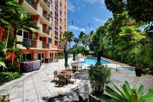 a hotel courtyard with a pool and tables and chairs at The Mutiny Luxury Suites Hotel in Miami