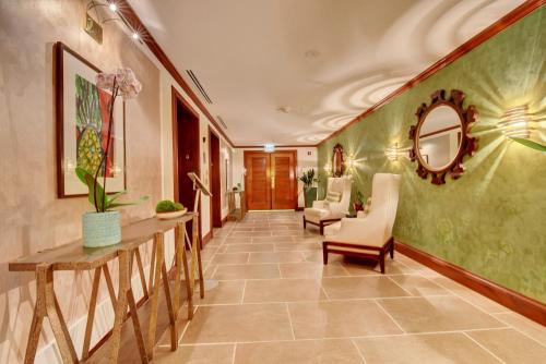 a hallway with green walls and chairs and a mirror at The Mutiny Luxury Suites Hotel in Miami