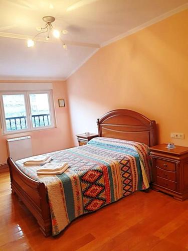 ein Schlafzimmer mit einem Bett mit einer Decke darauf in der Unterkunft Apartamento con vistas al mar, Costa da Morte in Cee