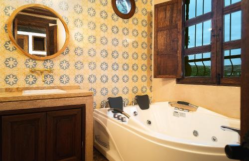 a bathroom with a tub and a sink and a mirror at Hotel Casa Alcestre in Villa de Leyva