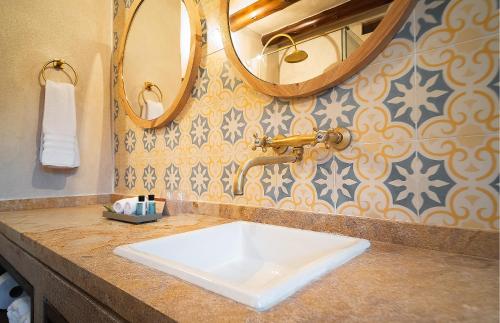 a bathroom with a sink and two mirrors at Hotel Casa Alcestre in Villa de Leyva
