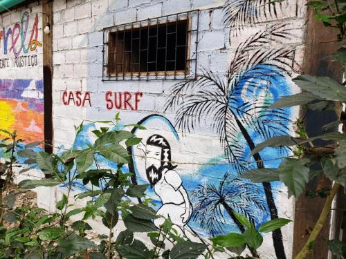 Una pared con una pintura de un hombre en ella en Casa surf arrels, en Montañita