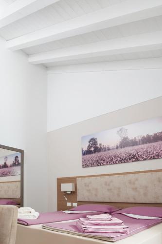 a white room with a bed with purple sheets at Al Reparo in Pederobba