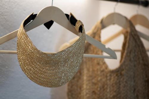 a straw hat and a dress on a hanger at Maison Kalogiannis in Patitiri