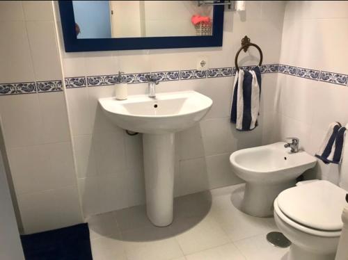 uma casa de banho com um lavatório e um WC em Apartamento DUPLEX CRUZ DEL MAR em Chipiona