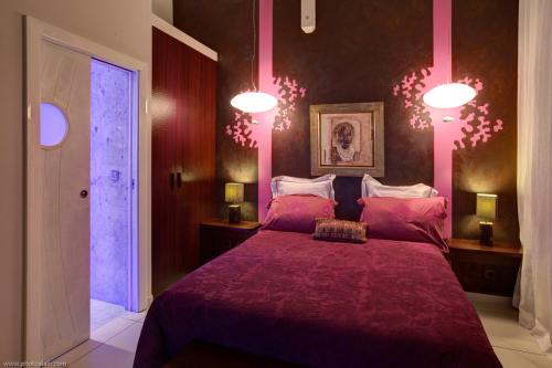 a bedroom with a large bed with a purple blanket at Villa Estheria in Sainte-Anne