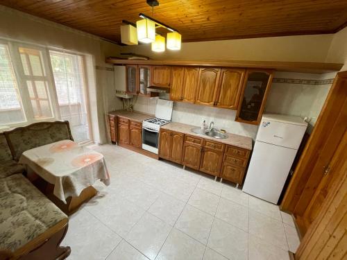 eine Küche mit einem Tisch und einem weißen Kühlschrank in der Unterkunft Villa Verde in Cricova