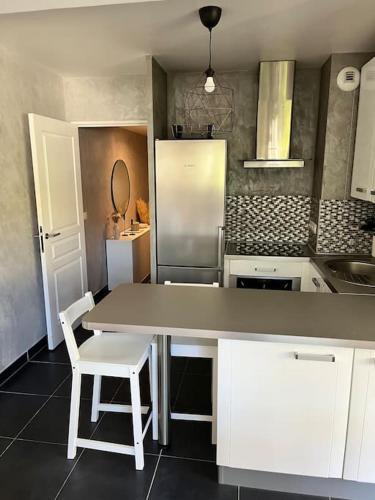 une cuisine avec une table et un réfrigérateur dans l'établissement Charmant 2 pièces proche Monaco - Parking privé, à Menton