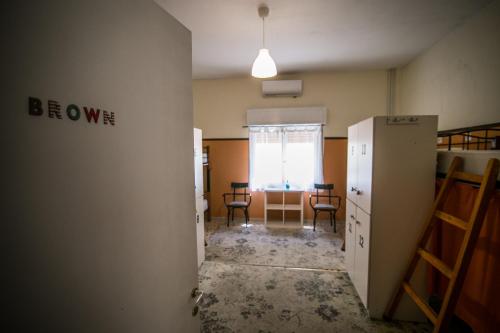 an empty room with a window and a room with a refrigerator at The Holy Rock - Hostel at meteora in Kalabaka