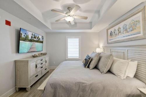 a bedroom with a bed and a ceiling fan at Modern Beach Vibe with a Breathtaking View - Stunning Pool - Pier Park in Panama City Beach