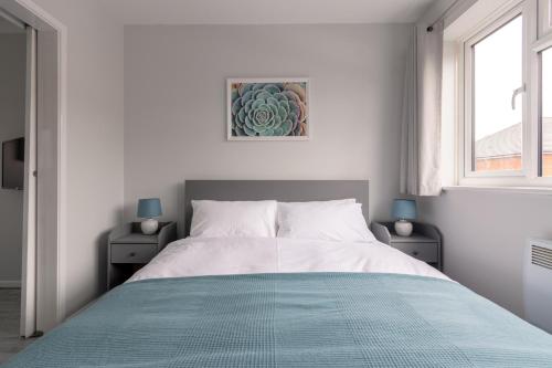 a white bedroom with a large bed and a window at Racecourse Revelation! Free parking in Newbury
