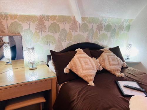 a bed with two pillows next to a desk at Fairfax in Skegness