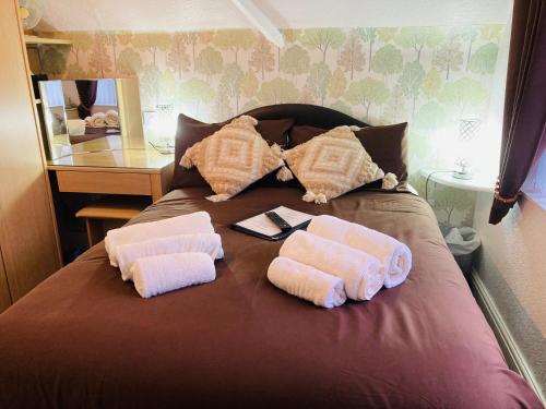 a bed with two towels on it with a mirror at Fairfax in Skegness