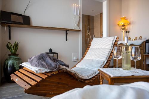 une chambre avec deux chaises et une table avec des verres à vin dans l'établissement Dat-Landhuus, à Molbergen