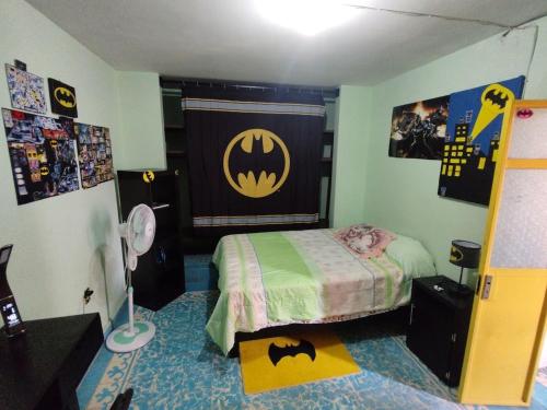 Dormitorio con póster de Batman en la pared en Casa El Colibrí CEC, en Tehuacán