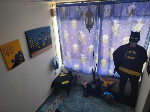 a room with a batman shower curtain and a cat at Casa El Colibrí CEC in Tehuacán
