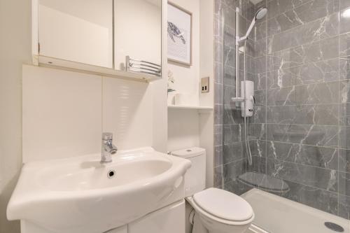 a white bathroom with a sink and a toilet at Racecourse Revelation! Free parking in Newbury