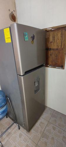 a refrigerator in a kitchen with magnets on it at Casa El Colibrí CEC in Tehuacán