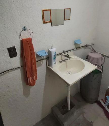 a bathroom with a sink and a trash can at Casa El Colibrí CEC in Tehuacán