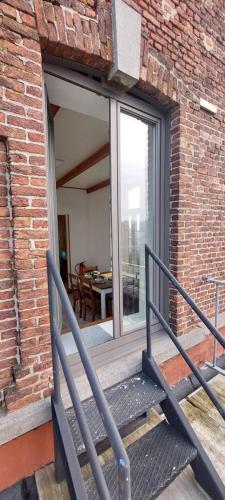 a balcony with a bench in front of a brick building at De oude statie in Tessenderlo
